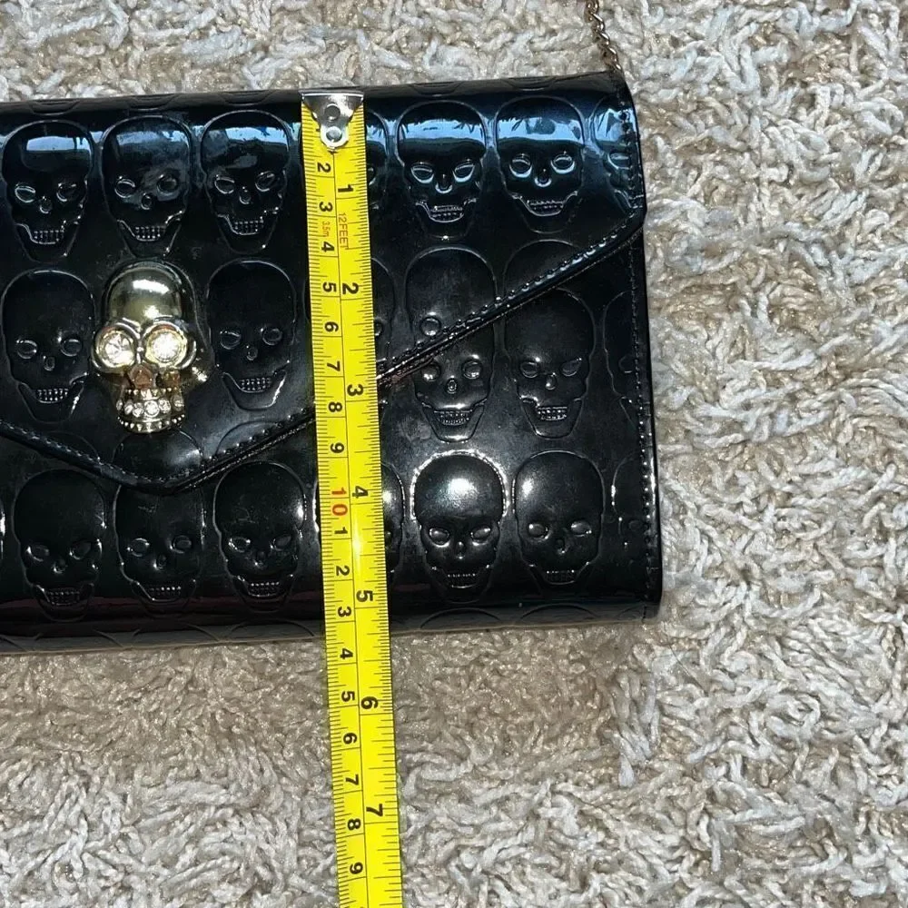Awesome patent leather skull embossed clutch bag with gold chain shoulder strap.